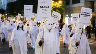 Un grupo de "mujeres anónimas" se ha concentrado en la Porta de la Mar vestidas con una túnica blanca y con máscaras del mismo color, portando velas y algunos de los nombres de las asesinadas.