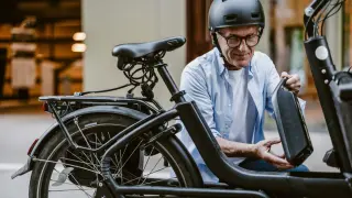 Un hombre instala el kit para convertir su bici en eléctrica.