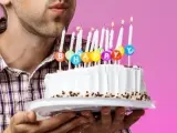 Un hombre sopla las velas de cumpleaños.