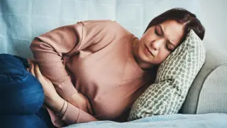 Una mujer se queja de dolor de estómago.